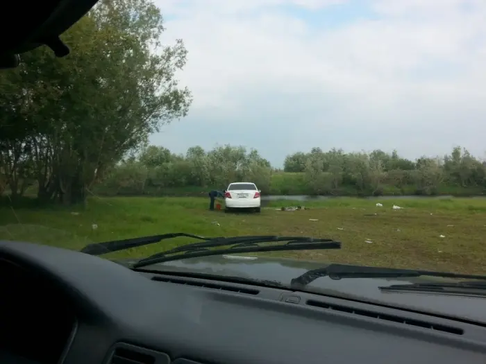 Дикая автомойка на зеленом лугу продолжает работу